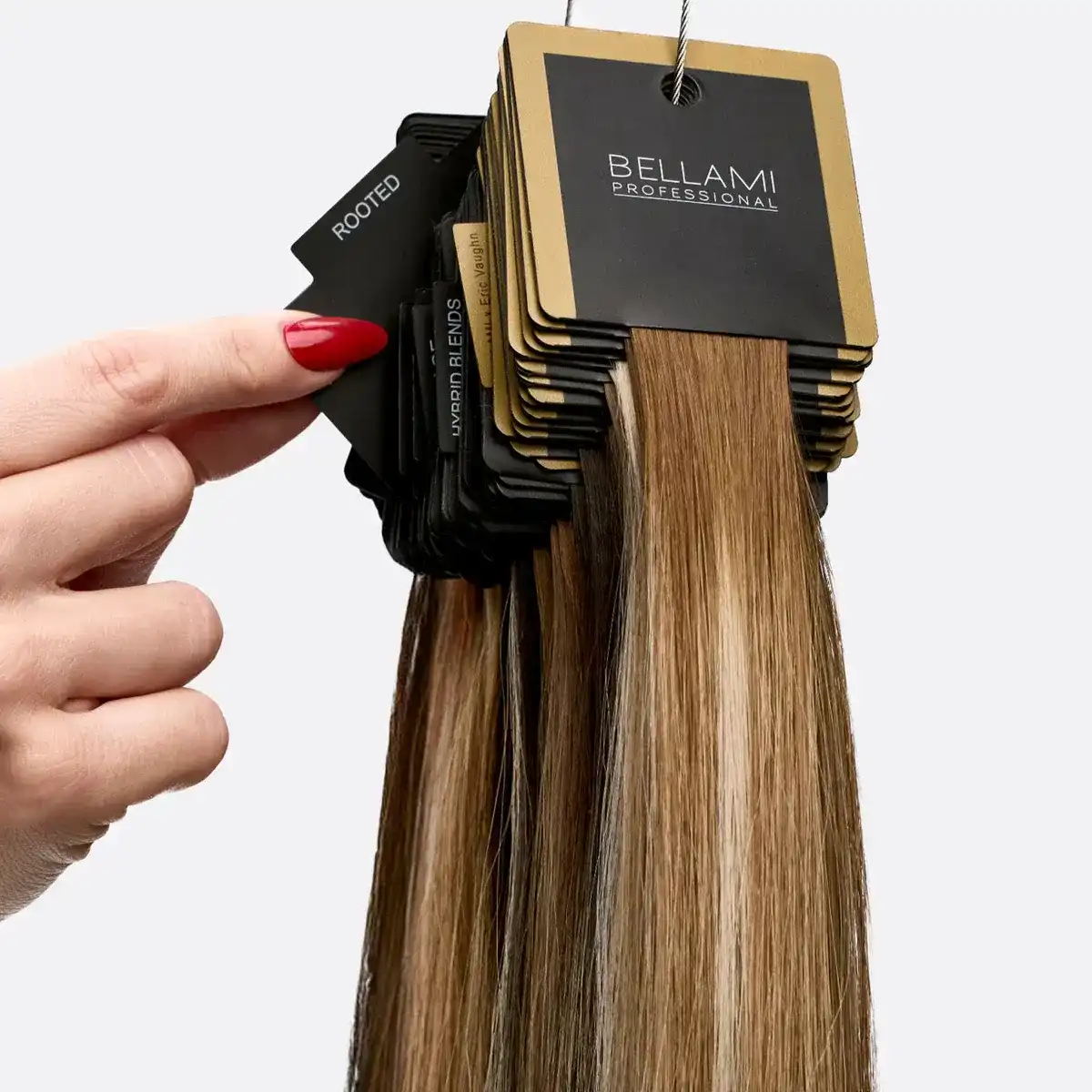 Hair extension color samples held by hand from Bellami Professional.